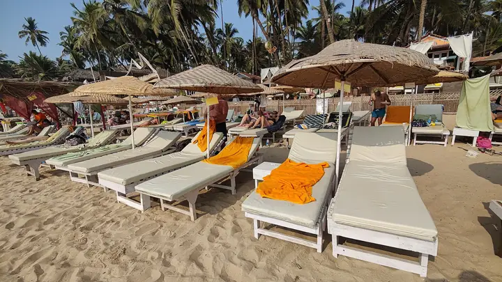 Sun loungers under umbrellas on a quiet Goa beach