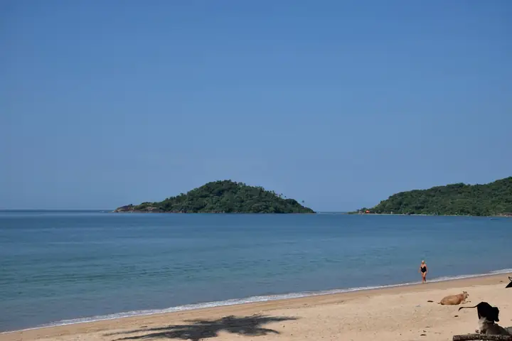 Calm blue water and a green island at Palolem, Goa